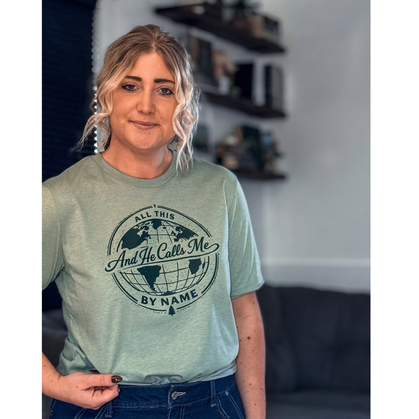 Person wearing a green t-shirt with a world map design and text in a casual setting.